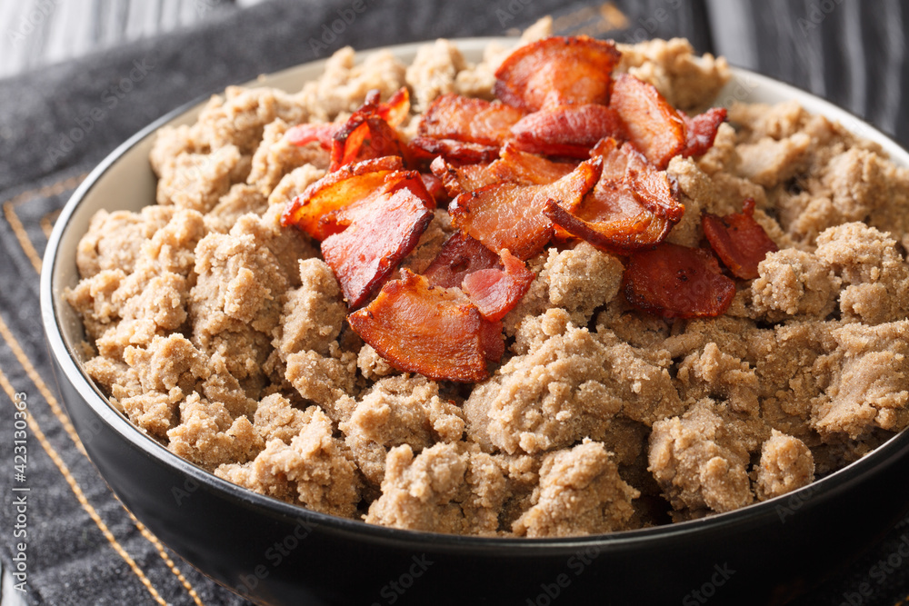 Popular food from Slovenia Ajdovi zganci made from buckwheat flour and fried bacon close-up in a bowl on the table. horizontal Popular food from Slovenia Ajdovi zganci made from buckwheat flour and fried bacon close-up in a bowl on the table. horizontal