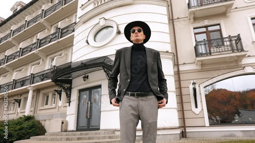 Wallpaper Mural The man is standing and looking at the camera. He's wearing sunglasses. He's stylishly dressed. 4K Torontodigital.ca