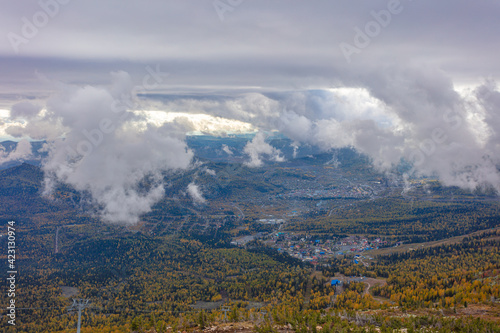 top view of a small industrial town in the mountains in autumn. Sheregesh in the morning in the clouds and fog before the ski season. ski resort © Wlad Go