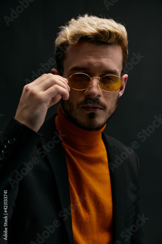 brutal guy with glasses orange sweater coat black background model