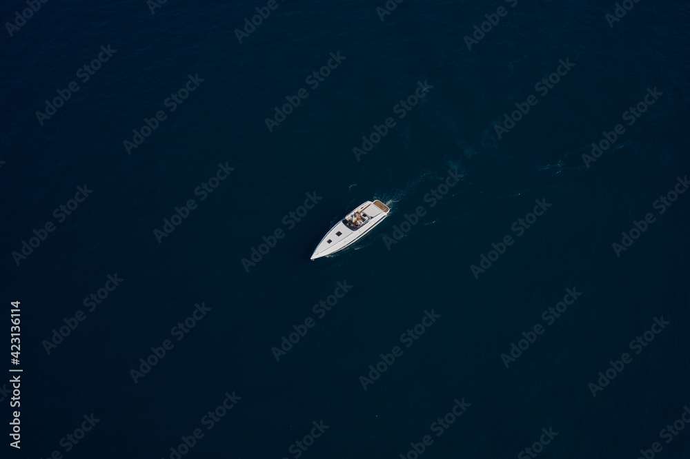 Aerial view luxury motor boat. Travel - image. Drone view of a boat  the blue clear waters. Top view of a white boat sailing to the blue sea