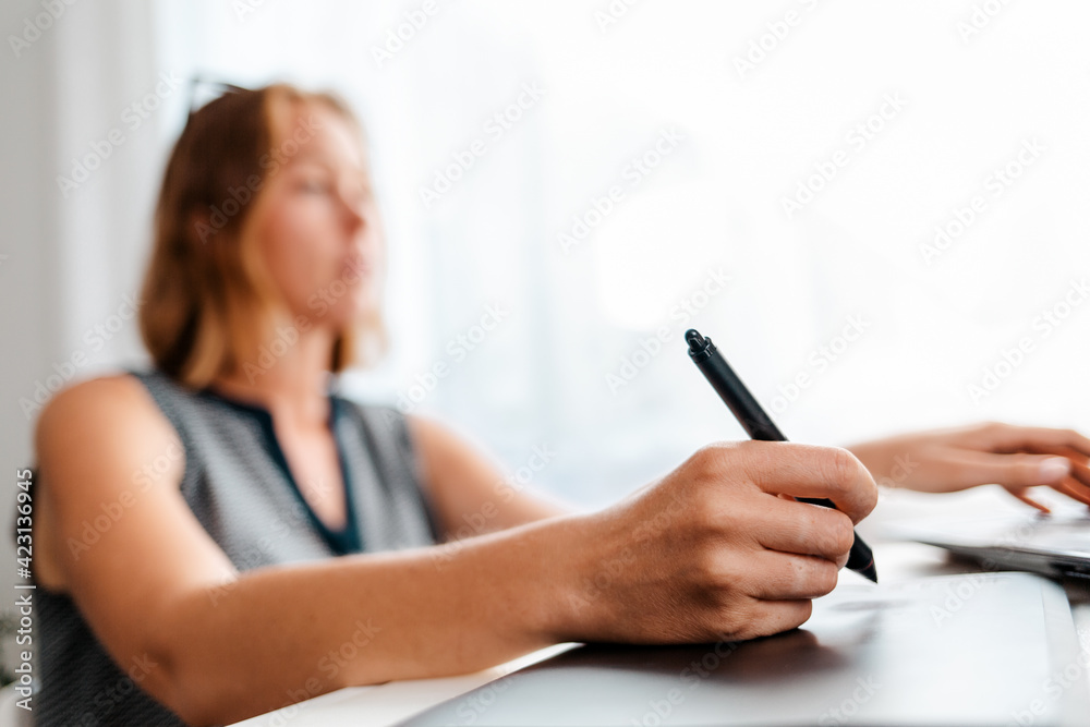 A blurry portrait of a young woman drawing on a tablet. Freelance and creative work A blurry portrait of a young woman drawing on a tablet. Freelance and creative work