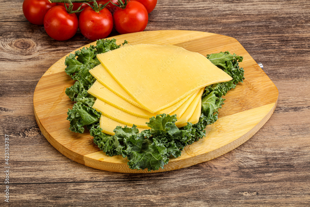Sliced Gauda cheese over board Sliced Gauda cheese over board