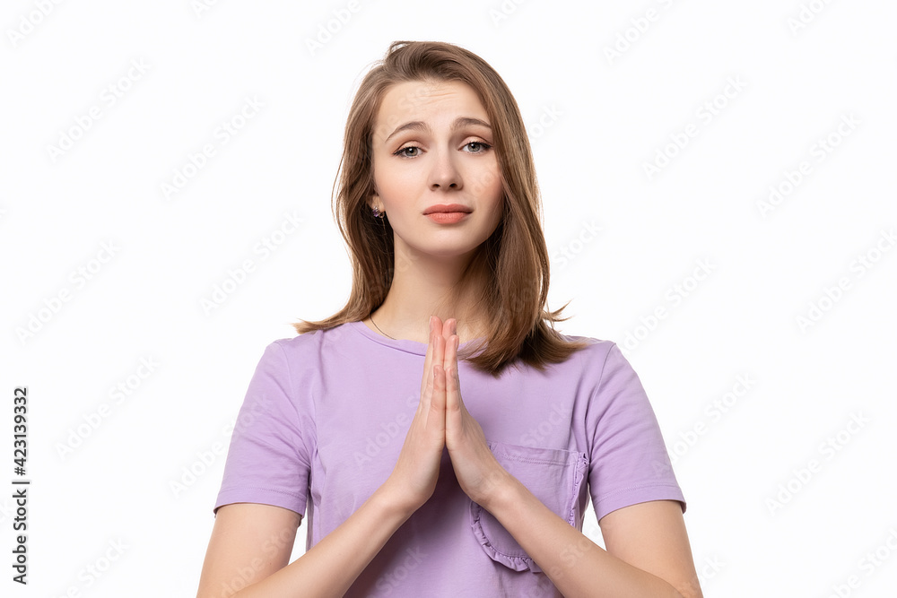 Attractive girl with folded hands asking help or forgiveness, praying with hope, isolated on white background Attractive girl with folded hands asking help or forgiveness, praying with hope, isolated on white background
