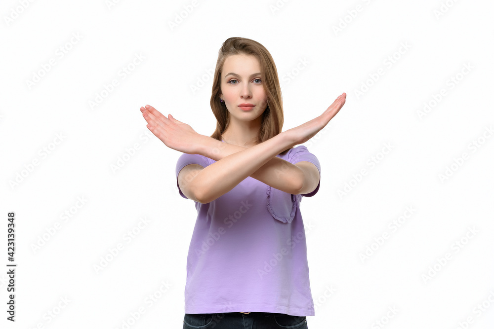 Serious young woman keeps two arms crossed, showing stop gesture while looking at camera. Denial concept Serious young woman keeps two arms crossed, showing stop gesture while looking at camera. Denial concept