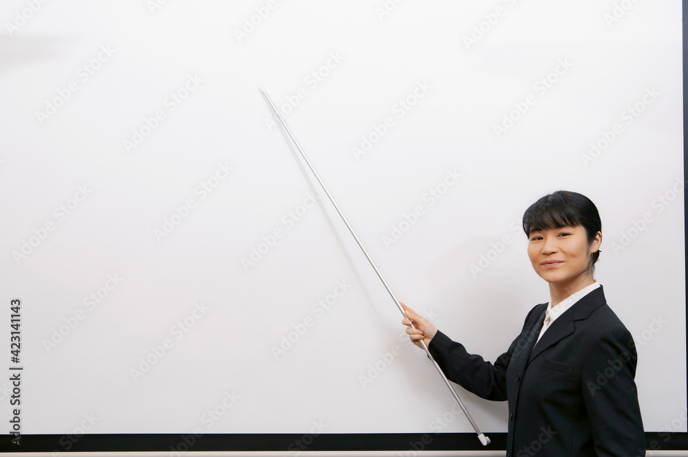 Portrait confident businesswoman with pointer at whiteboard
Portrait confident businesswoman with pointer at whiteboard