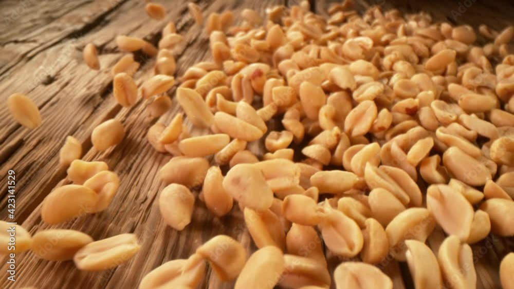 Super Slow Motion Detail Shot of Peanuts Rolling Towards on Wooden Background at 1000fps with Camera Motion.