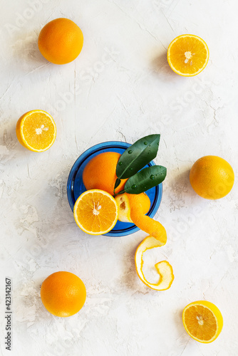 Oranges with leaves in a blue glass plate. Vertical orientation, top view.