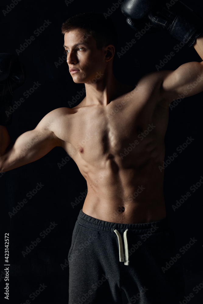 guy with a pumped-up torso gesturing with his hands on a black background boxing gloves guy with a pumped-up torso gesturing with his hands on a black background boxing gloves