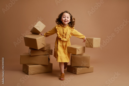 Happy smiling girl breaking stacks of gifts