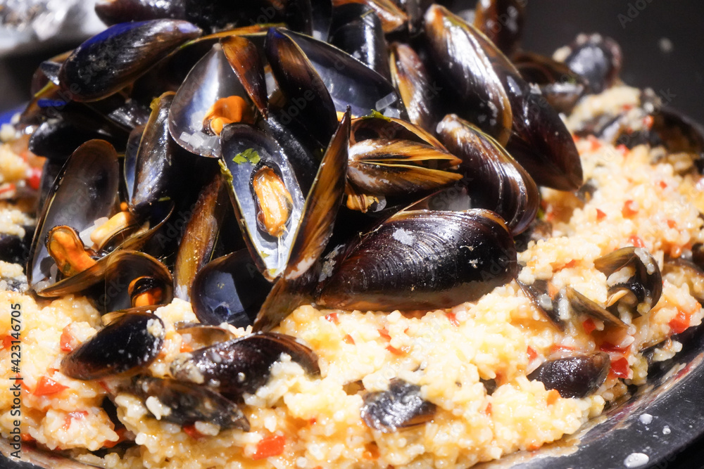 Natural shells cooked in wine on a bed of rice with vegetables. Product photography. Natural shells cooked in wine on a bed of rice with vegetables. Product photography.