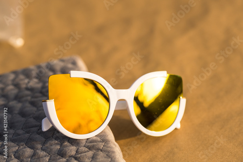 Cat eye sunglasses special model for women golden lenses and whit frames color shoot outside in a summer day closeup. Selective focus . High quality photo
