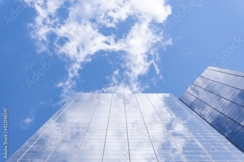 View from the ground of two buildings with blue sky and clouds