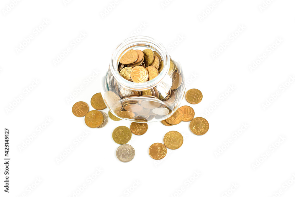 Metal coins in a glass jar isolated on a white background. Keeping personal savings. Financial crisis, ruble devaluation. Copy space for text. Selective focus. Metal coins in a glass jar isolated on a white background. Keeping personal savings. Financial crisis, ruble devaluation. Copy space for text. Selective focus.