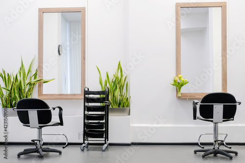 Workplace for two hairdressers The interior of the hairdressing salon with a professional chairs and equipment is ready to receive visitors.