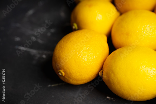 Ripe bright lemons on the dark rustic background. Selective focus. Shallow depth of field.