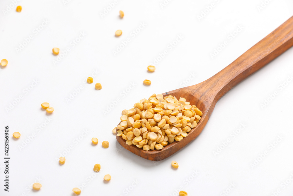 dry and organic chickpea pulses in wooden spoon on white background