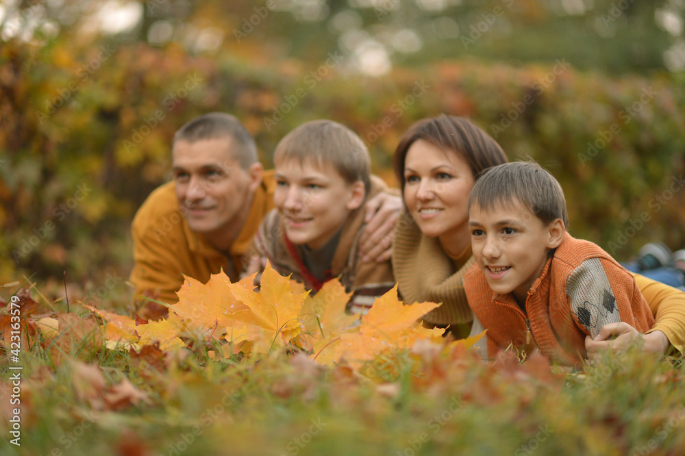 Family of four relaxing in autumn park Family of four relaxing in autumn park