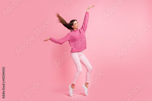 Full size photo of brunette funny girl dance wear pink sweater pants sneakers isolated on crimson background
