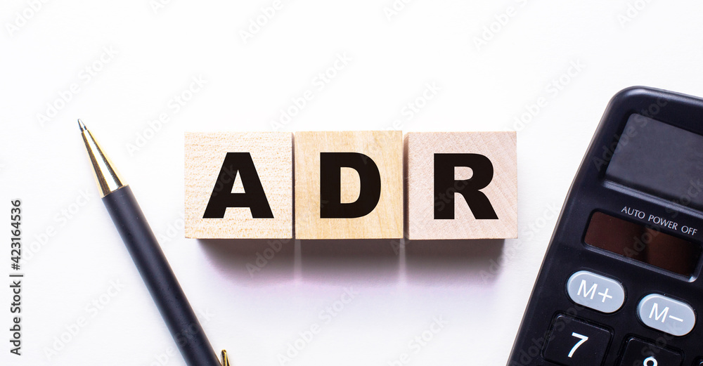 The words ADR Alternative Dispute Resolution is written on wooden cubes between a pen and a calculator on a light background. The words ADR Alternative Dispute Resolution is written on wooden cubes between a pen and a calculator on a light background.