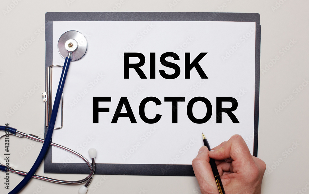 On a light background, a stethoscope and a sheet of paper, on which a man writes RISK FACTOR. Medical concept On a light background, a stethoscope and a sheet of paper, on which a man writes RISK FACTOR. Medical concept