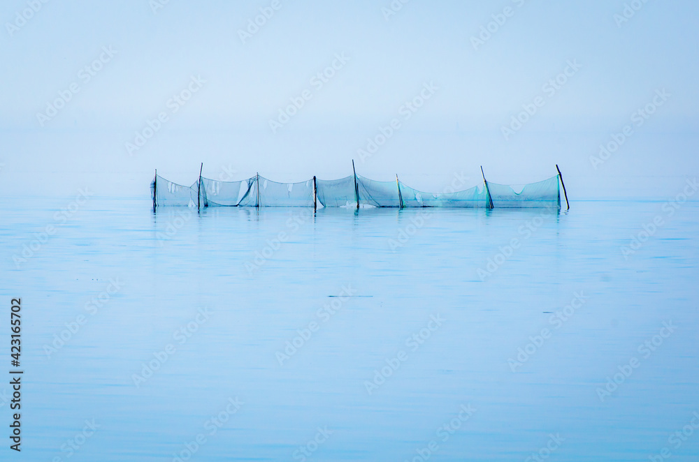 Paesaggio invernale della laguna di Venezia con reti da pesca
