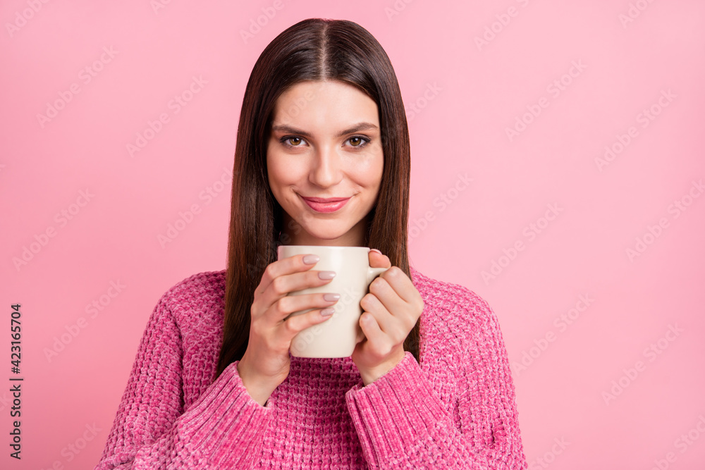 Portrait of brunette optimistic girl hold cup wear pink sweater isolated on crimson color background Portrait of brunette optimistic girl hold cup wear pink sweater isolated on crimson color background
