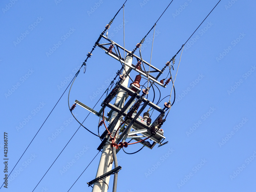 Close up of power poles and towers in the background of blue sky Close up of power poles and towers in the background of blue sky