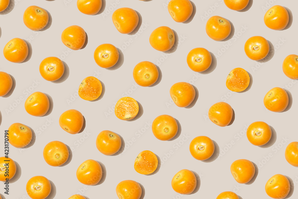 Golden berries pattern on gray background.