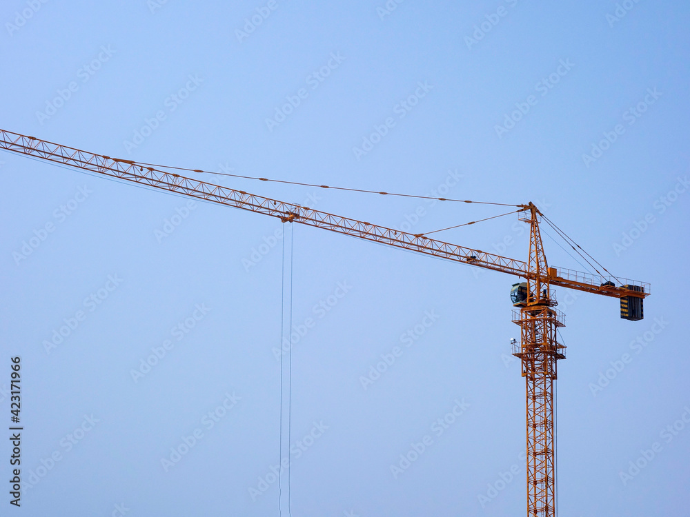 The tower crane on the construction site is busy working