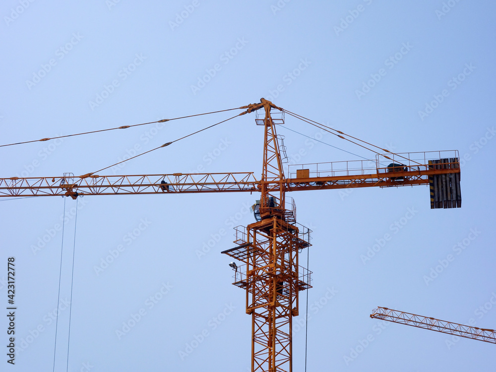 The tower crane on the construction site is busy working