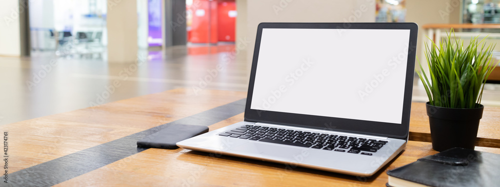 Laptop computer with white blank screen on desk in workspace and copy space concept - obrazy, fototapety, plakaty 