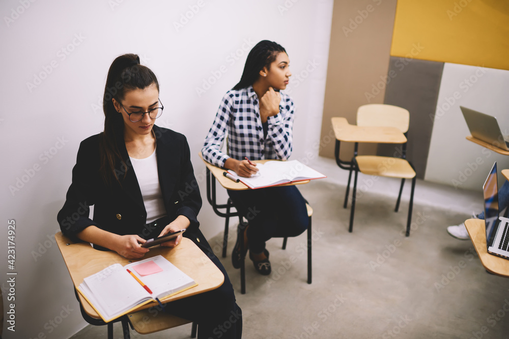 Women students studying in classroom together Women students studying in classroom together