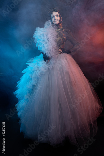 Fairy creature, historical character, fantasy queen, witch, in fairy costume Woman, model after 60, in the studio, dark background