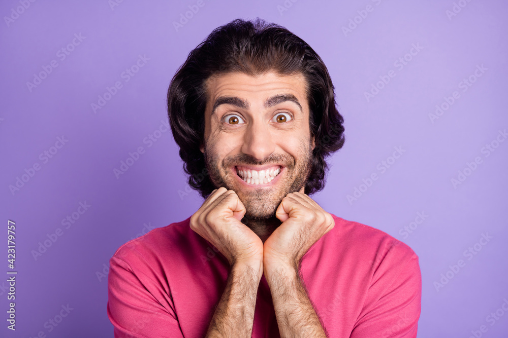 Photo of optimistic nice brunet guy hands cheeks wear pink t-shirt isolated on pastel violet color background Photo of optimistic nice brunet guy hands cheeks wear pink t-shirt isolated on pastel violet color background