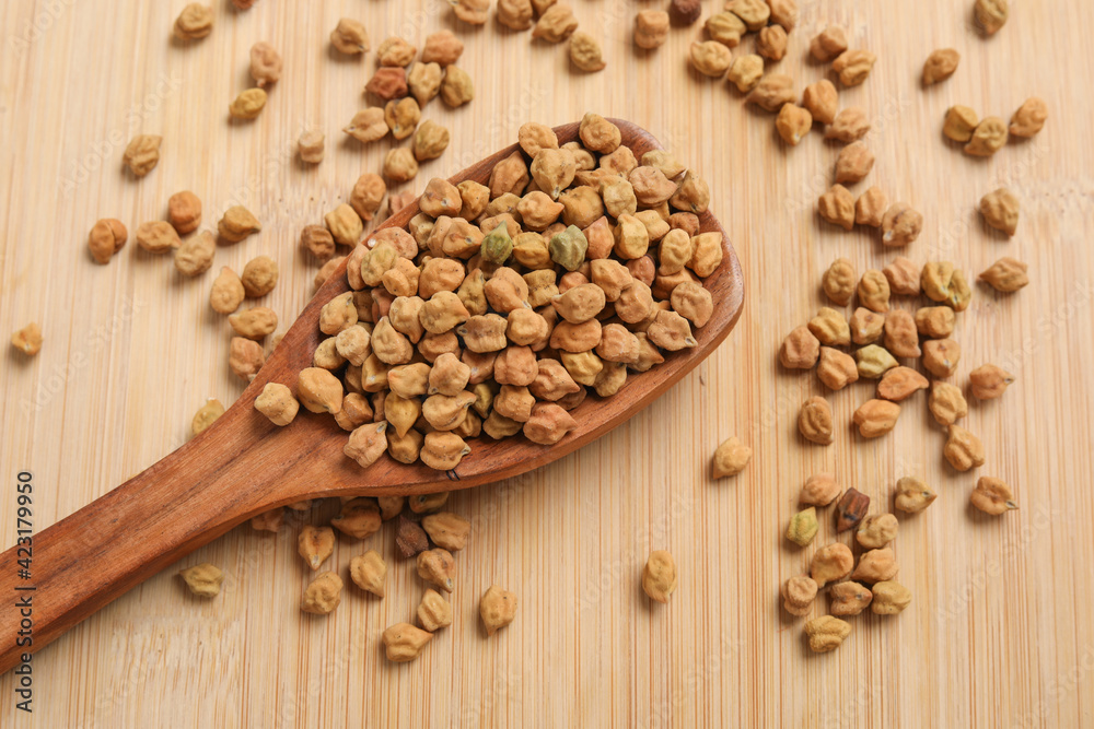 Dried chickpeas in wooden spoon on wooden background. Dried chickpeas in wooden spoon on wooden background.
