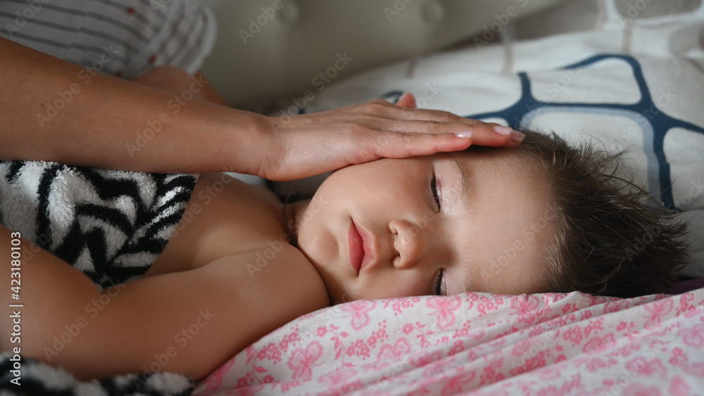 Close up of mother stroking head of sleeping baby son. Caring for child concept. Close up of mother stroking head of sleeping baby son. Caring for child concept.