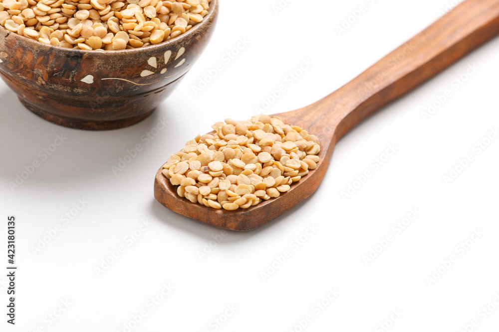 Unpolished Pigeon pea also known as toor dal in a bowl and spoon. Isolated on white background. Unpolished Pigeon pea also known as toor dal in a bowl and spoon. Isolated on white background.