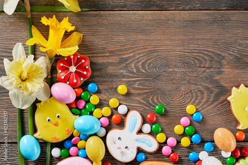 Dark wooden background with easter gingerbread and daffodils