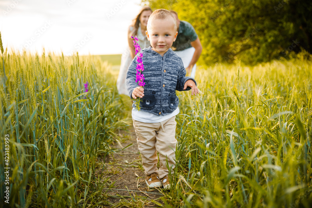 Child boy runs across a green field. Child boy runs across a green field.