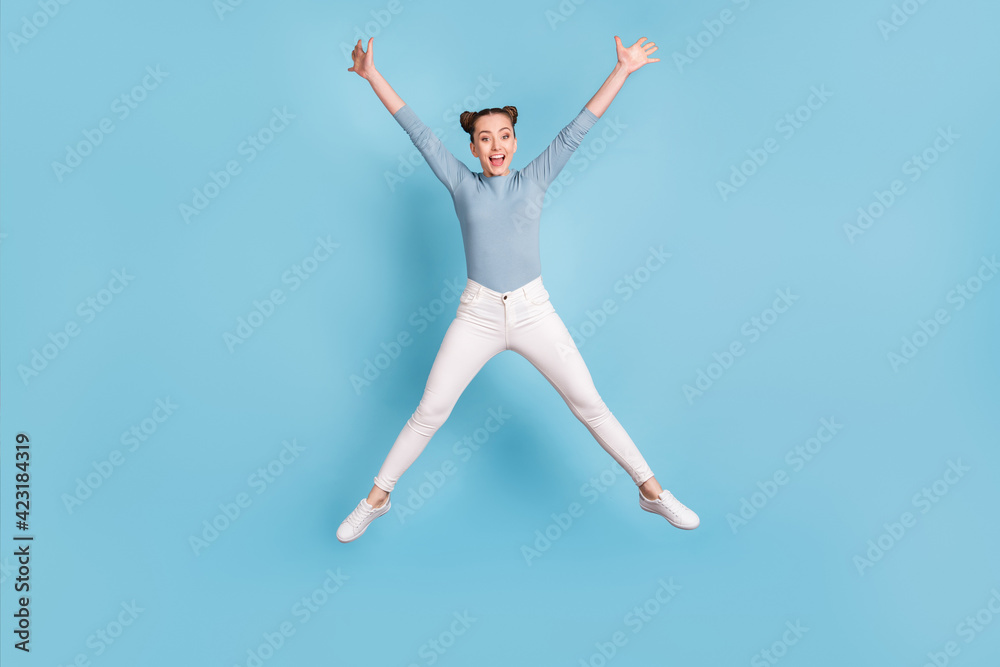 Full length photo of positive pretty young girl jump up air star pose isolated on blue color background