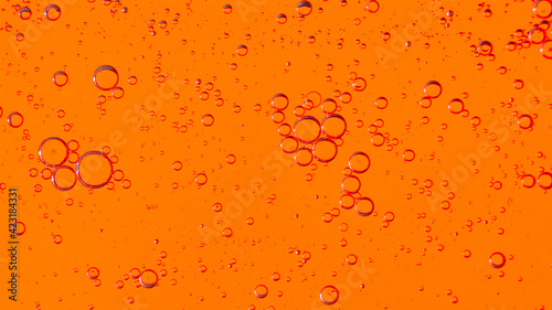 Oil bubbles on the water surface in motion, on a yellow-red background, macro, splash screen, template, copy space