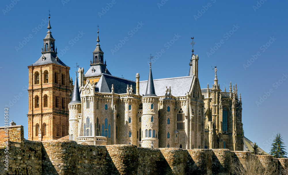 View of historic cathedral and landmark Gaudi building surrounded by ancient Roman  surrounding wall in the city of Astorga, Spain.