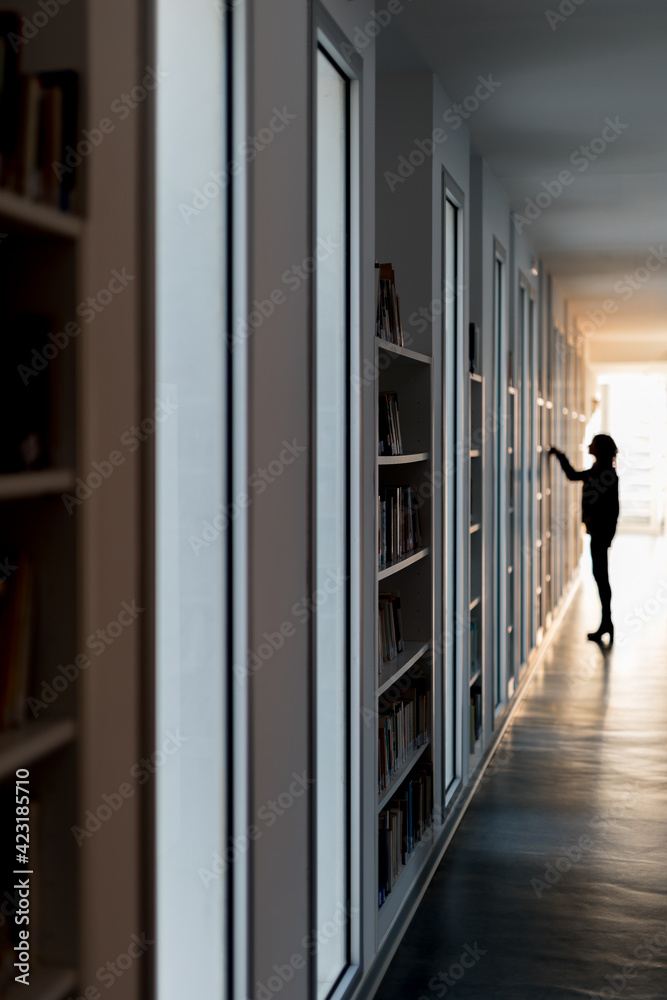 person selecting a book at the library person selecting a book at the library