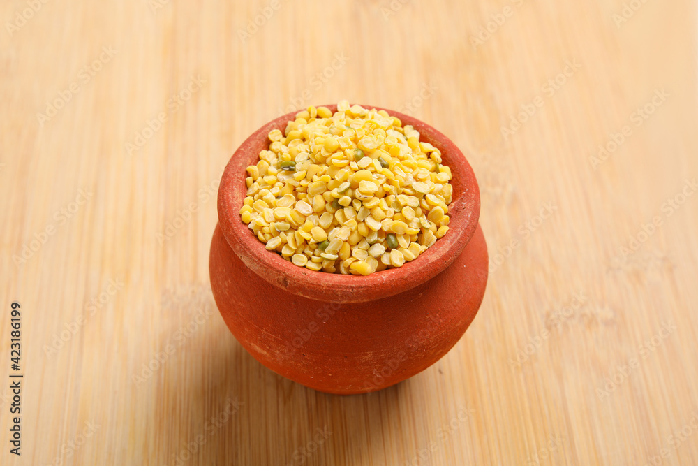yellow moong mung dal lentil pulse bean in wooden bowl on wooden background.