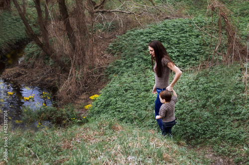 the mother leads the child by the hand to the stream in the spring  when the yellow flowers bloom