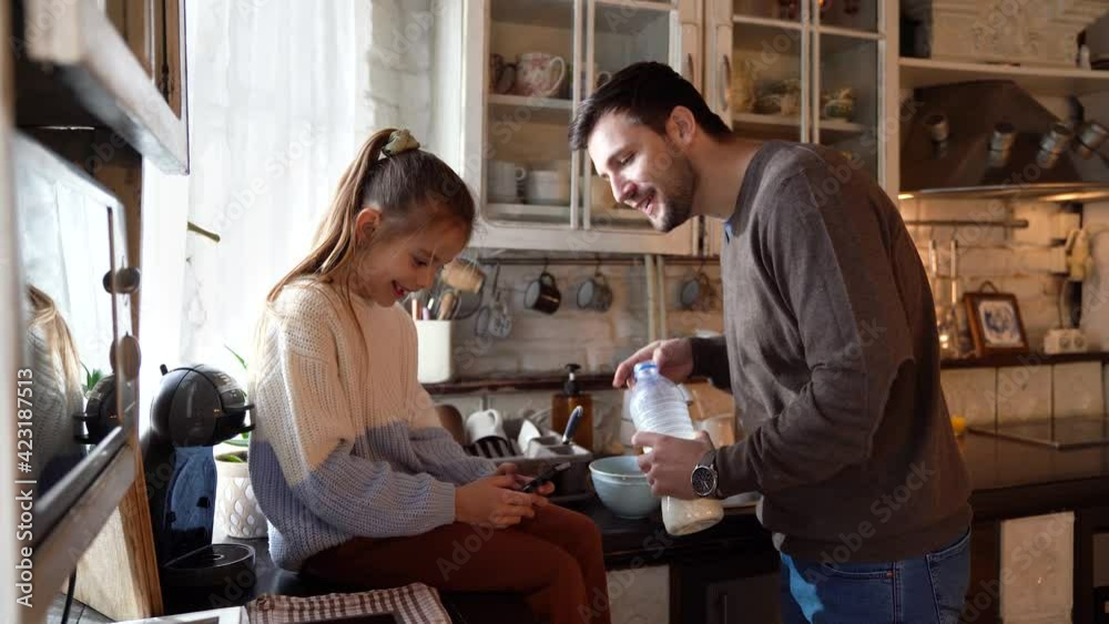 Cheerful father and his daughter having breakfast together Cheerful father and his daughter having breakfast together