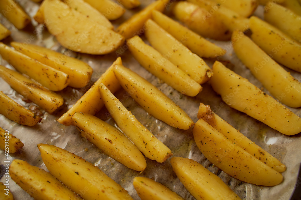 Fresh potatoes cut into slices lies on a foil surface Fresh potatoes cut into slices lies on a foil surface