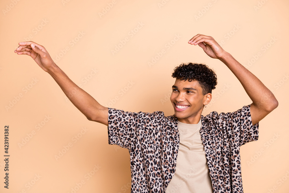 Photo of brunet optimistic guy dance arms up wear modern shirt isolated on  beige color background Stock Photo | Adobe Stock