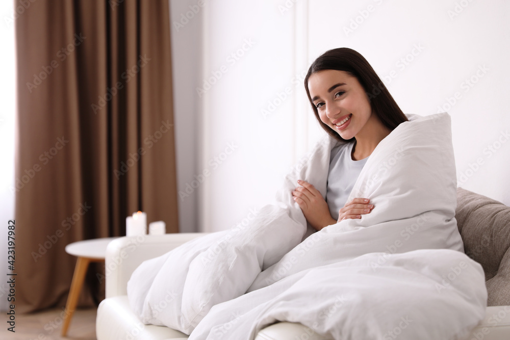Woman covered in blanket resting on sofa, space for text Woman covered in blanket resting on sofa, space for text